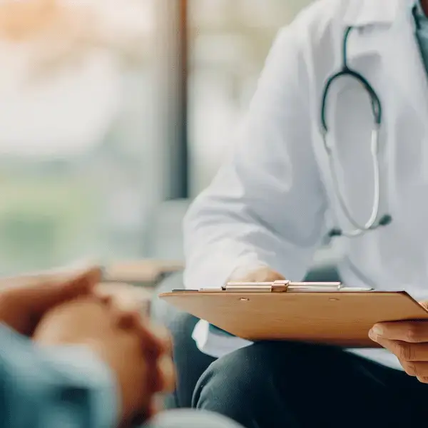 Doctor consulting with a patient and writing notes on a clipboard at Nazarenus Hospital Out-Patient Department in Bulacan